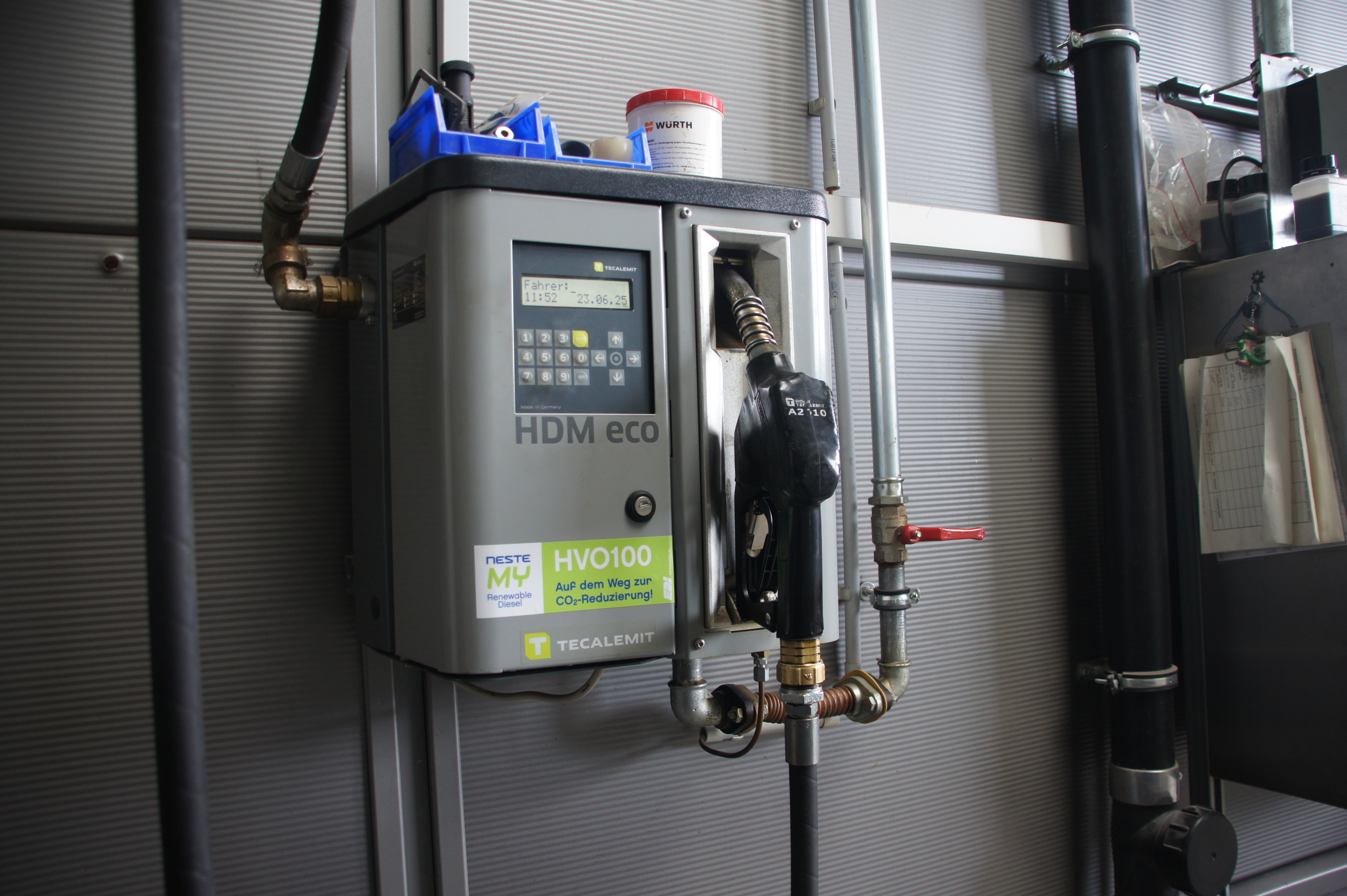 Kraftstoffpumpe HDM eco, grau, mit Schläuchen und digitalem Display, industrieller Hintergrund.