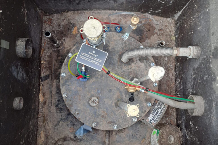 Metallbehälter mit Kabeln in verschiedenen Farben und Armaturen in einem Schacht