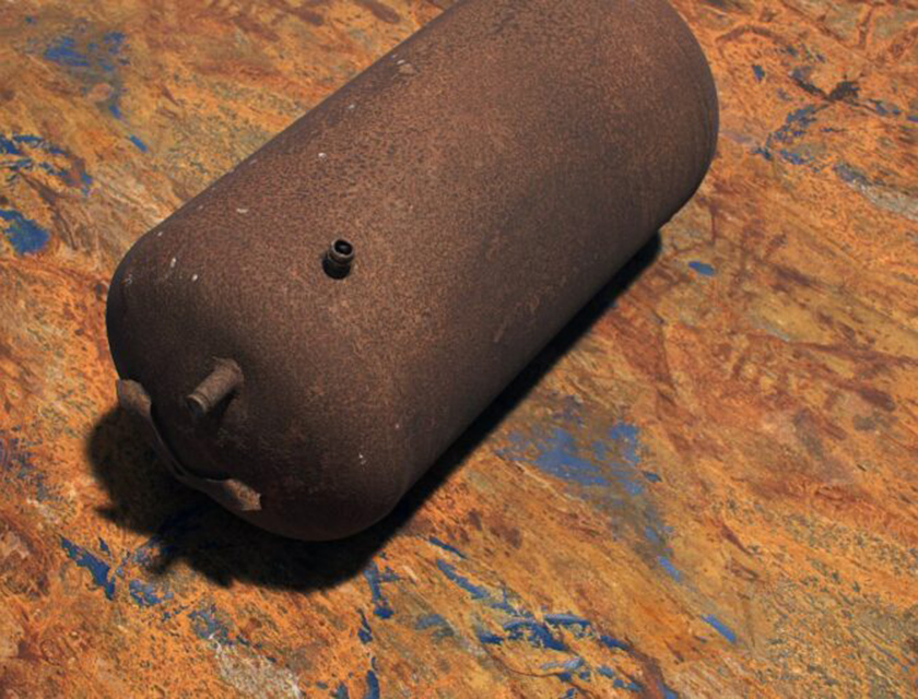 Ein rostiger Metallzylinder liegt schräg auf einer bunten, verkratzten Fläche